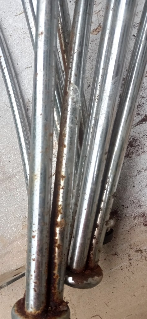Close-up of several rusted metal rods piled together on a light surface.